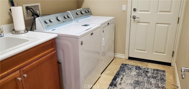 clothes washing area featuring separate washer and dryer and cabinet space