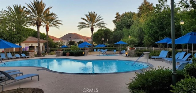 pool with fence, a mountain view, and a patio