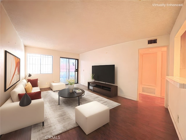 living area with baseboards, visible vents, and dark wood-style floors