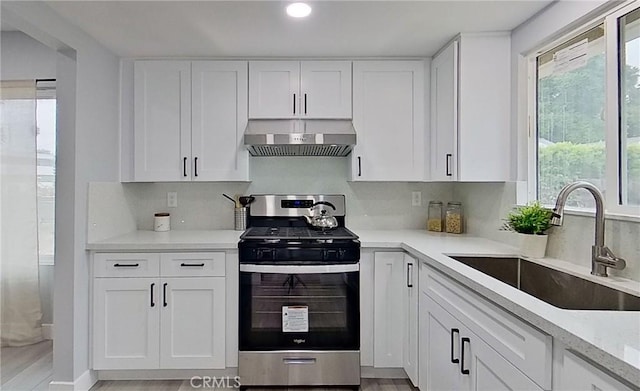 805 Earlham St, Pasadena, CA 91101 - kitchen featuring exhaust hood, stainless steel gas stove, backsplash, a sink, and white cabinets