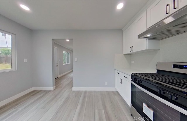 805 Earlham St, Pasadena, CA 91101 - kitchen with white cabinets, stainless steel gas range, baseboards, under cabinet range hood, and light wood-style floors