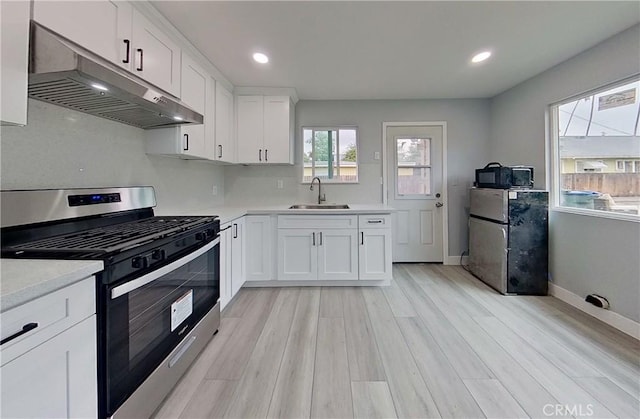 805 Earlham St, Pasadena, CA 91101 - kitchen featuring light countertops, a sink, stainless steel gas range, under cabinet range hood, and light wood-style floors