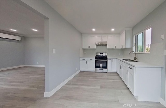 805 Earlham St, Pasadena, CA 91101 - kitchen featuring light countertops, stainless steel gas stove, a sink, a wall unit AC, and under cabinet range hood