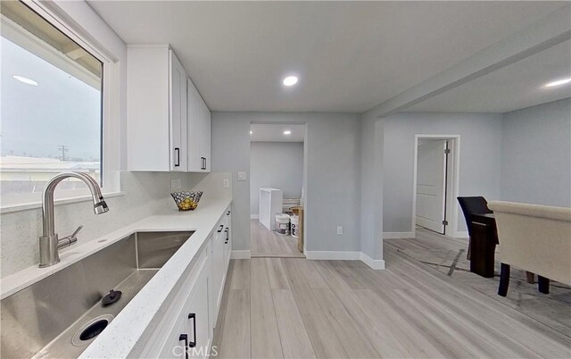 805 Earlham St, Pasadena, CA 91101 - kitchen featuring white cabinetry, light countertops, light wood-type flooring, baseboards, and a sink