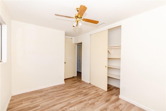unfurnished bedroom with visible vents, baseboards, a closet, and wood finished floors
