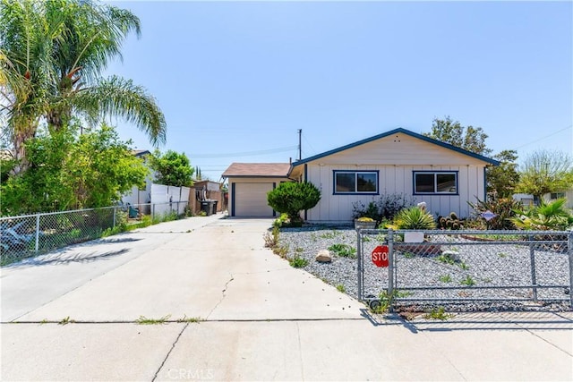 view of front of house featuring a garage, driveway, and a fenced front yard