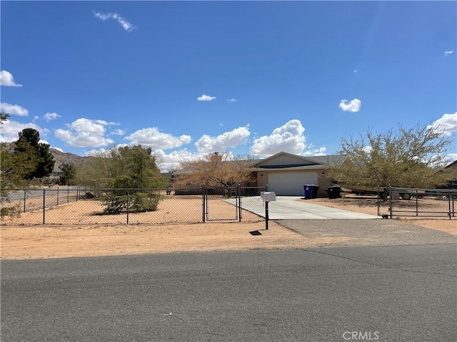 view of property hidden behind natural elements with concrete driveway, a gate, fence private yard, and a garage
