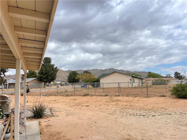 view of yard with a mountain view, fence, and a rural view