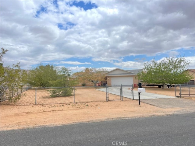 view of front facade featuring a garage, concrete driveway, and fence