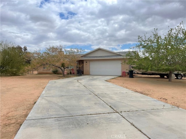ranch-style house featuring concrete driveway, stucco siding, and a garage