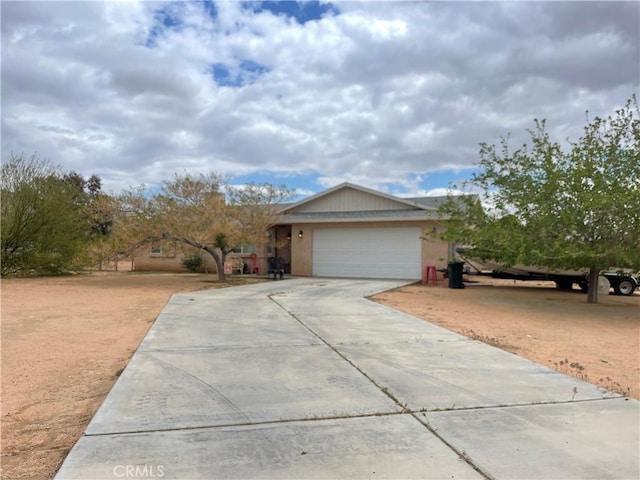 view of front of property with an attached garage, driveway, and stucco siding
