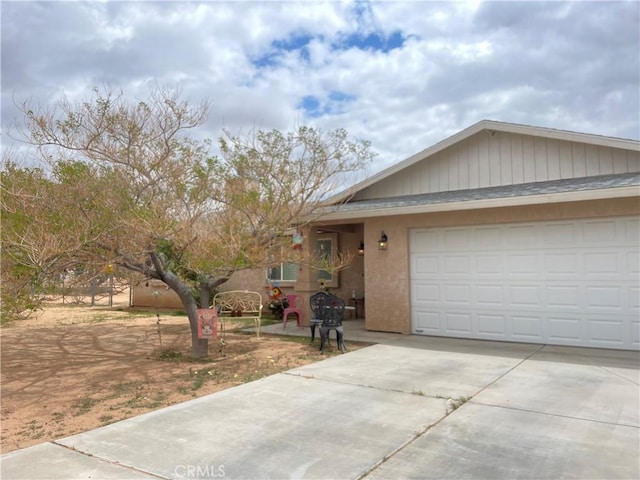 ranch-style home featuring stucco siding, driveway, and a garage