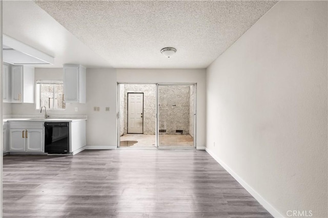 19231 Sherman Way Unit 44, Reseda, CA 91335 - unfurnished living room with a sink, a textured ceiling, baseboards, and wood finished floors