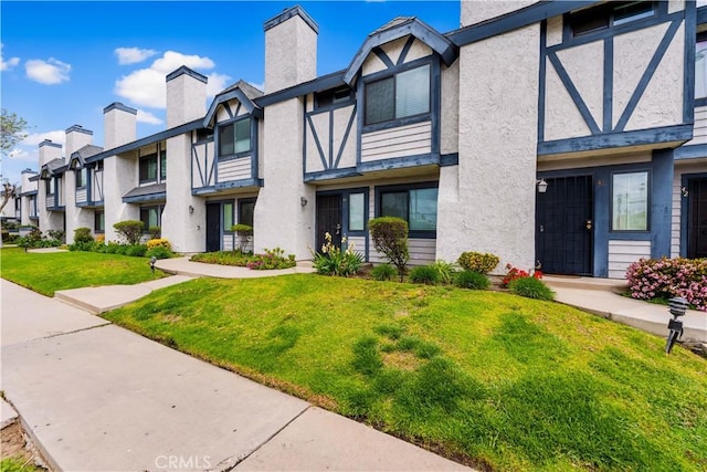19231 Sherman Way Unit 44, Reseda, CA 91335 - exterior space featuring stucco siding, a chimney, a yard, and a residential view