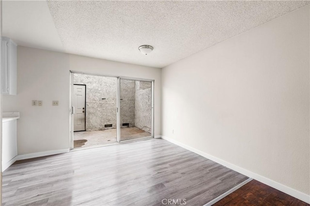 19231 Sherman Way Unit 44, Reseda, CA 91335 - unfurnished bedroom with baseboards, access to exterior, and wood finished floors