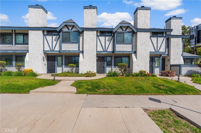 19231 Sherman Way Unit 44, Reseda, CA 91335 - exterior space with stucco siding, a front lawn, and a chimney
