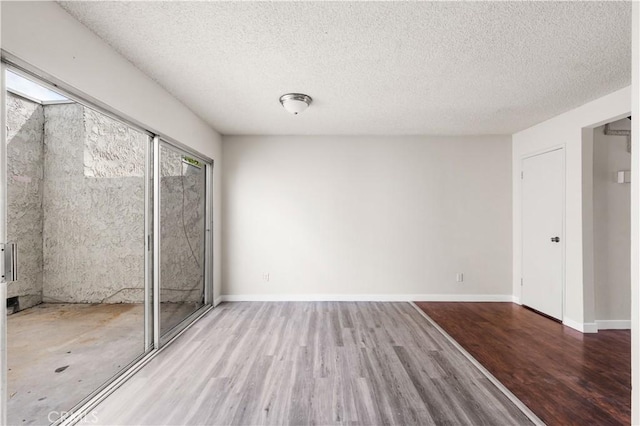 19231 Sherman Way Unit 44, Reseda, CA 91335 - unfurnished bedroom with a textured ceiling, baseboards, and wood finished floors