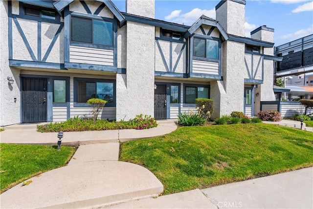 19231 Sherman Way Unit 44, Reseda, CA 91335 - view of front facade with a front yard, stucco siding, and a chimney