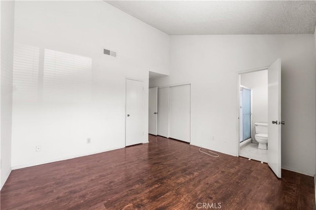 19231 Sherman Way Unit 44, Reseda, CA 91335 - unfurnished bedroom featuring ensuite bathroom, lofted ceiling, visible vents, and wood finished floors