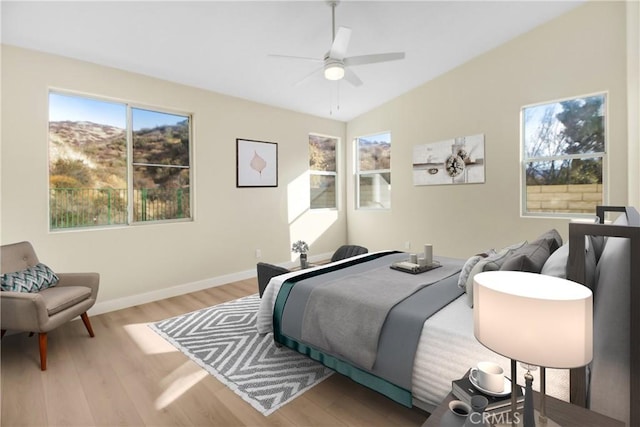 bedroom with baseboards, a ceiling fan, lofted ceiling, and wood finished floors