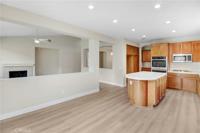 kitchen featuring ceiling fan, appliances with stainless steel finishes, light wood-style flooring, recessed lighting, and open floor plan