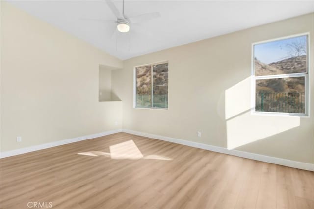 unfurnished room with baseboards, a wealth of natural light, and light wood-type flooring