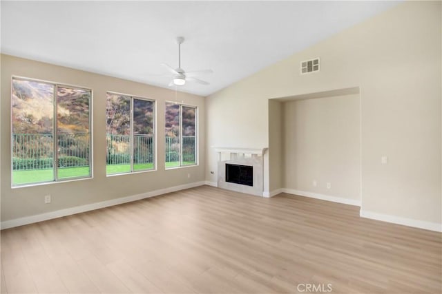 unfurnished living room featuring ceiling fan, visible vents, baseboards, lofted ceiling, and light wood-style flooring