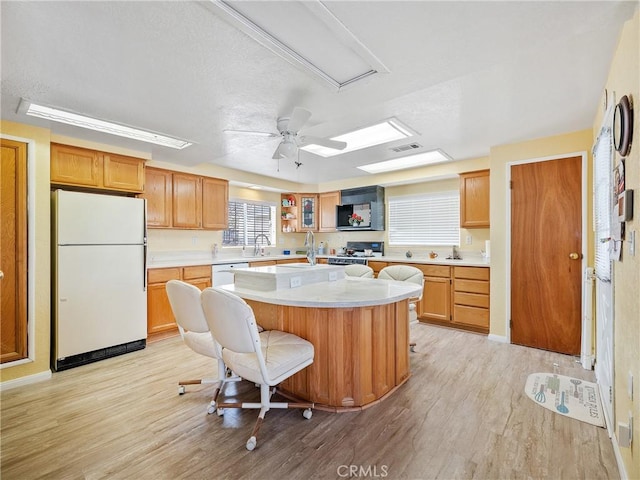 9160 Ox Bow Rd, Lucerne Valley, CA 92356 - kitchen featuring light countertops, light wood-style floors, a center island, and white appliances