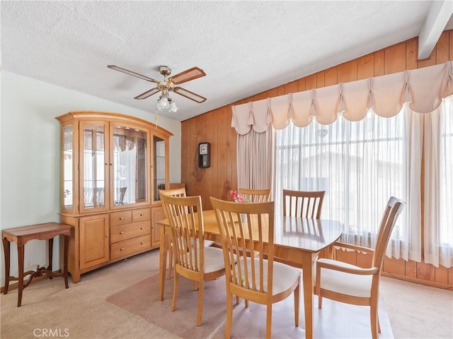 9160 Ox Bow Rd, Lucerne Valley, CA 92356 - dining area featuring a textured ceiling, wood walls, a ceiling fan, and light carpet