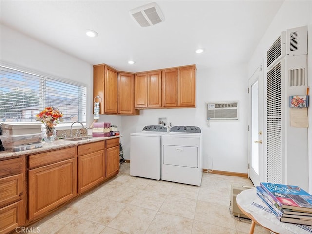 9160 Ox Bow Rd, Lucerne Valley, CA 92356 - clothes washing area featuring a wall unit AC, separate washer and dryer, a sink, visible vents, and cabinet space