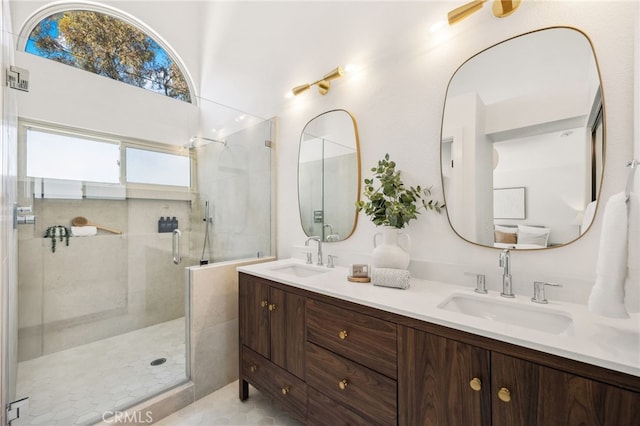 bathroom featuring a sink, tiled shower, and double vanity