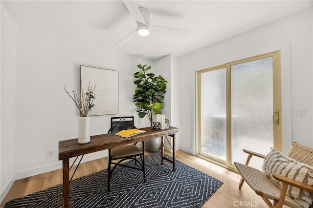 office with a ceiling fan, baseboards, light wood finished floors, and a healthy amount of sunlight
