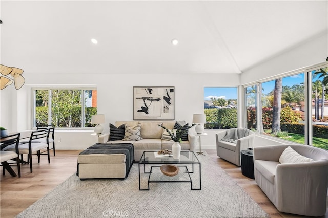 living area featuring recessed lighting, baseboards, light wood-style floors, and lofted ceiling with beams