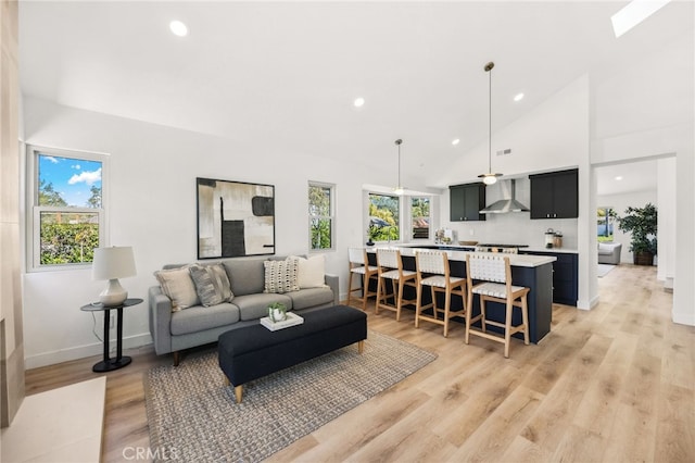living room with baseboards, recessed lighting, high vaulted ceiling, and light wood finished floors
