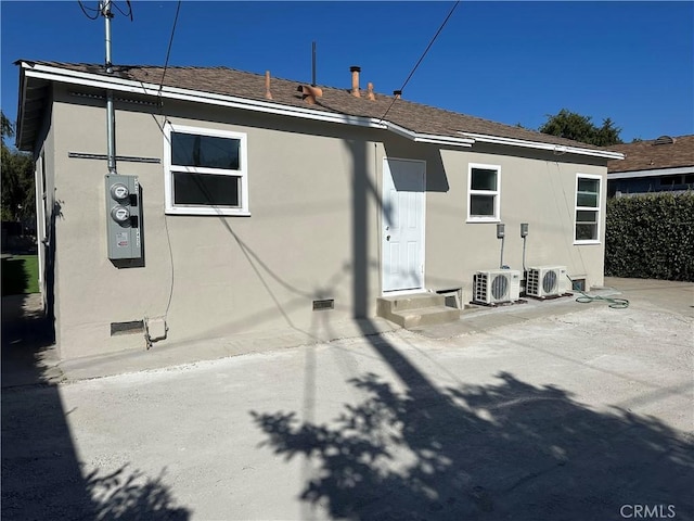 rear view of property featuring ac unit and stucco siding
