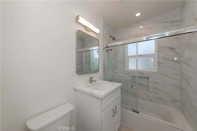 bathroom with combined bath / shower with glass door, toilet, and vanity