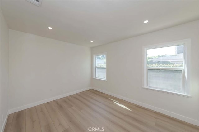 unfurnished room with light wood finished floors, baseboards, visible vents, and recessed lighting