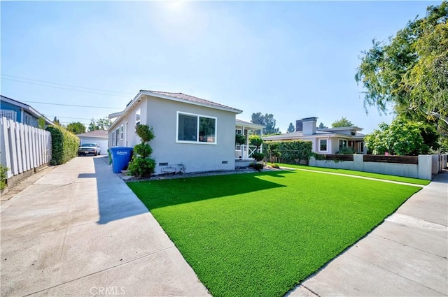 view of front of home with stucco siding, fence, a front lawn, and crawl space