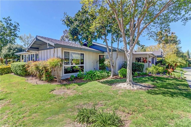 single story home with board and batten siding and a front lawn