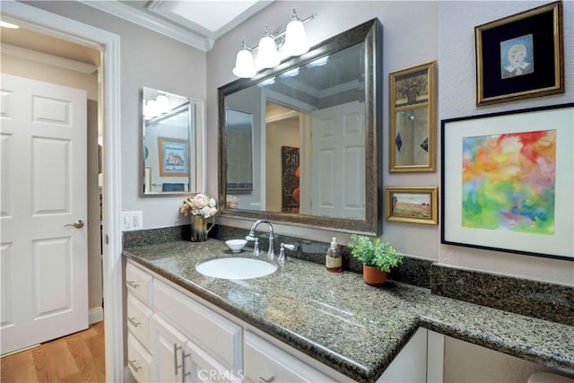 bathroom with crown molding, wood finished floors, and vanity