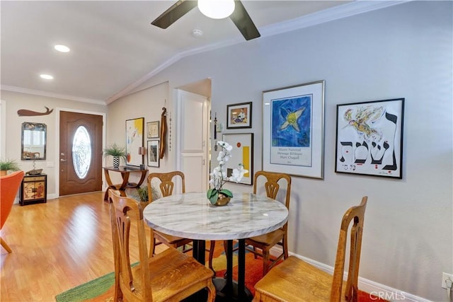 dining room featuring baseboards, ornamental molding, a ceiling fan, wood finished floors, and lofted ceiling