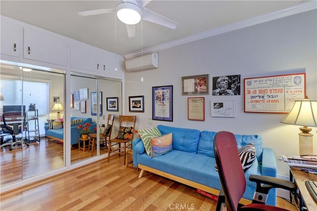 office space with ornamental molding, an AC wall unit, ceiling fan, and light wood-style floors
