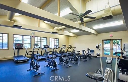 gym with lofted ceiling, french doors, a ceiling fan, and a healthy amount of sunlight