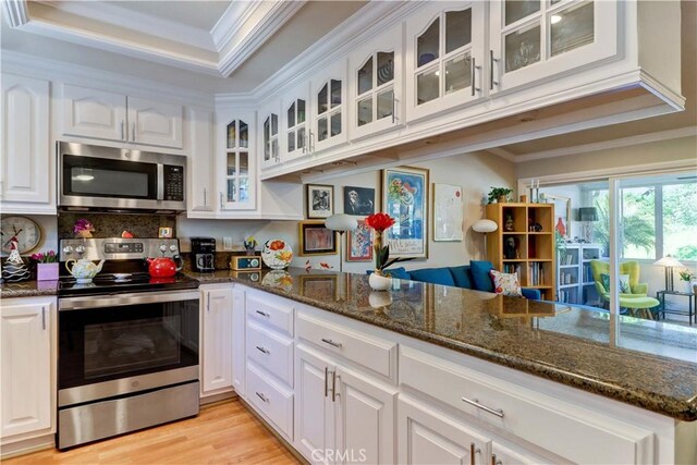 kitchen with crown molding, light wood-style floors, white cabinets, and stainless steel appliances