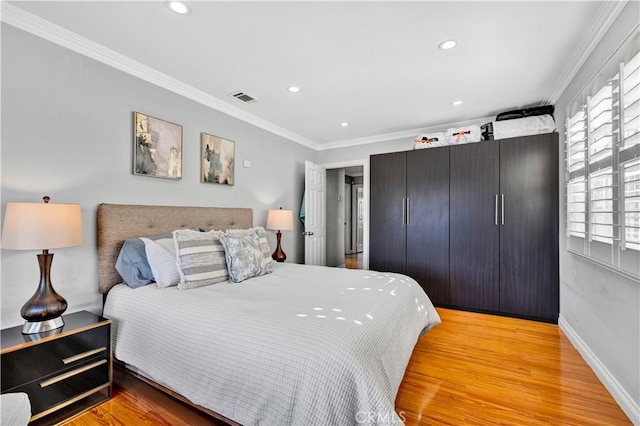 bedroom with crown molding, light wood-style flooring, baseboards, visible vents, and recessed lighting