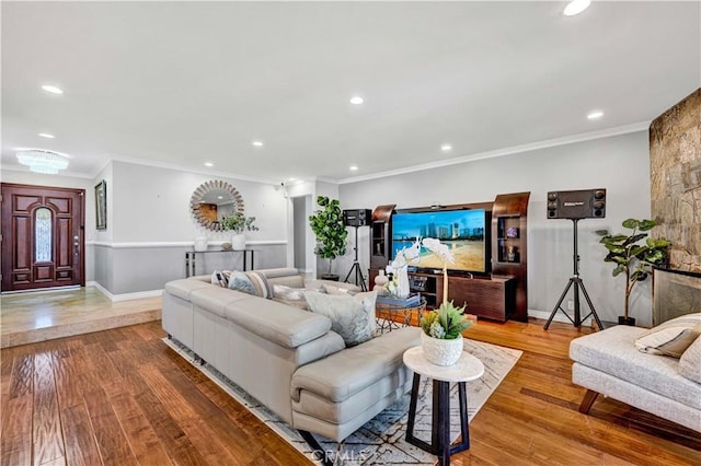 living room featuring recessed lighting, hardwood / wood-style flooring, baseboards, and crown molding