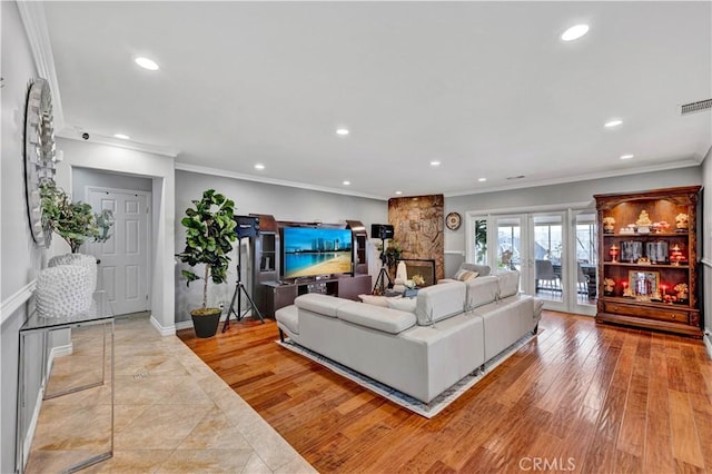 living room featuring wood finished floors, recessed lighting, crown molding, and visible vents