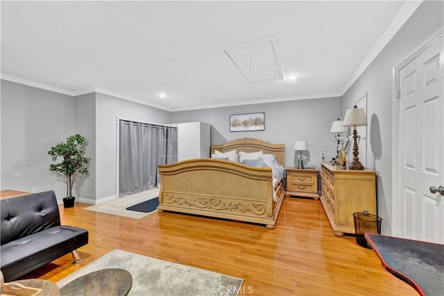 bedroom with crown molding, baseboards, light wood-style flooring, and attic access