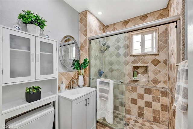 full bathroom featuring toilet, a stall shower, and vanity