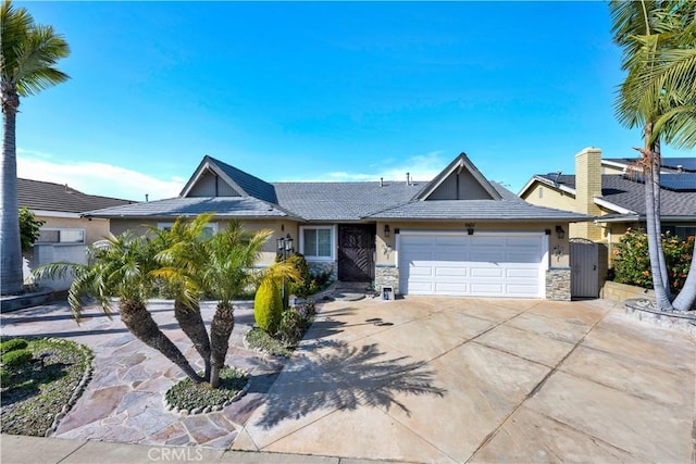 single story home with driveway, a gate, an attached garage, and stone siding